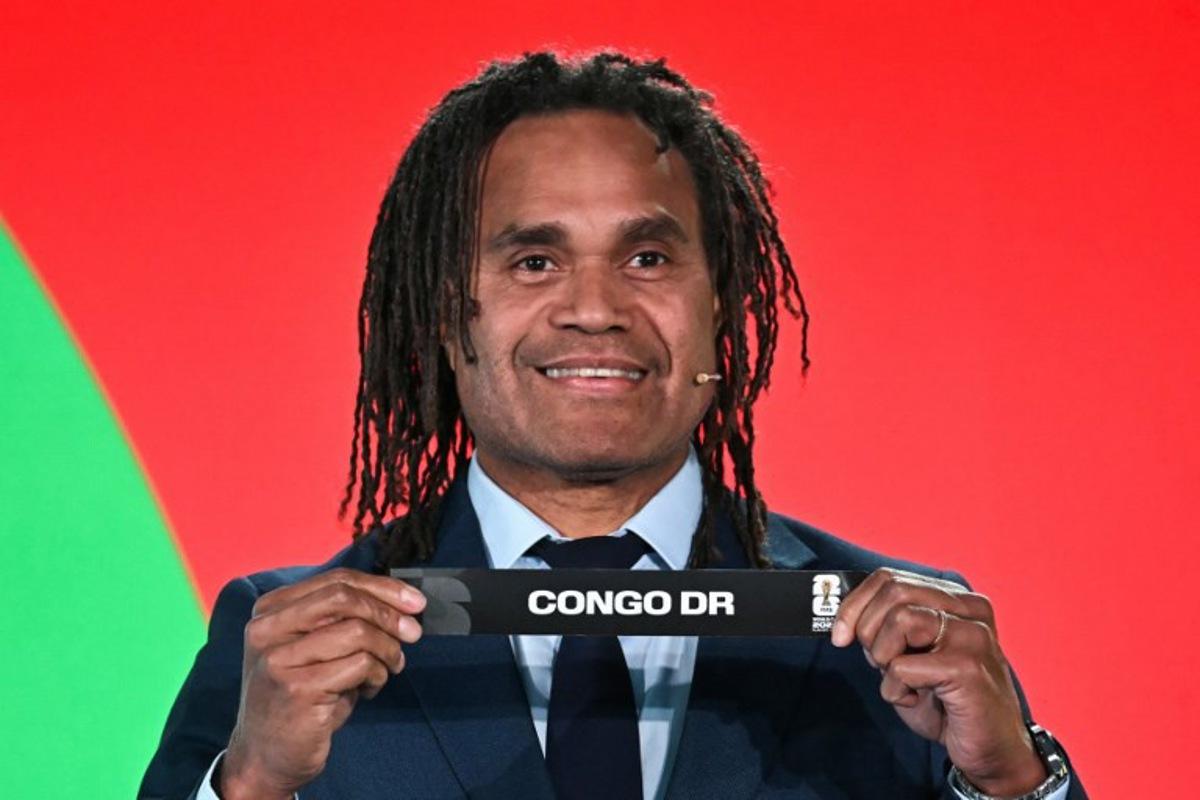 French former player Christian Karembeu shows the paper slip of DR Congo during the 2026 FIFA World Cup Play-Off Tournament draw at the FIFA's Home of Football in Zurich on November 20, 2025.  Fabrice COFFRINI / AFP