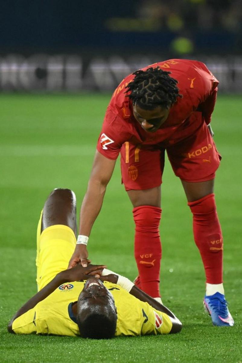 Valencia's Belgian forward # 17 Largie Ramazani (TOP) checks on Villarreal's Senegalese midfielder #18 Pape Gueye during the Spanish league football match between Villarreal CF and Valencia CF at La Ceramica Stadium in Vila-real on February 22, 2026.  JOSE JORDAN / AFP