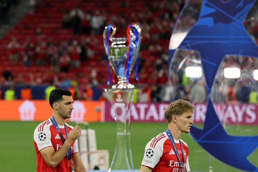 Arsenal's Spanish midfielder #23 Mikel Merino (L) and Arsenal's Norwegian midfielder #08 Martin Odegaard walk past the trophy following the UEFA Champions League final football match between Paris Saint-Germain (PSG) and Arsenal FC at the Puskas Arena in Budapest on May 30, 2026.   Odd ANDERSEN / AFP