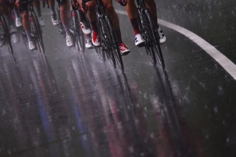 The pack rides under the rain during the sixth stage of the Giro d'Italia 2021 cycling race, 160 km between Grotte di Frasassi and Ascoli Piceno (San Giacomo) on May 13, 2021.   Dario BELINGHERI / AFP