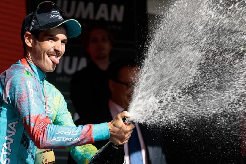 XDS Astana Team's Italian rider Christian Scaroni sprays champagne as he celebrates on the podium after victory in the 16th stage of the 108th Giro d'Italia cycling race of 203kms from Piazzola sul Brenta to San Valentino on May 27, 2025.  Luca Bettini / AFP