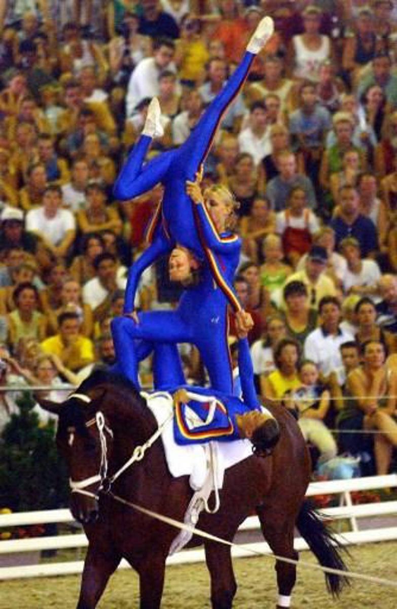 Les voltigeurs allemands, exécutent une figure le 10 août 2003 à Saumur lors des Championnats d'Europe Open Voltige. Ils remportent l'épreuve par équipe.   German acrobats performs a figure, 10 August 2003 in Saumur, western France, during European equestrian Acrobatics Championship. AFP PHOTO FRANK PERRY.