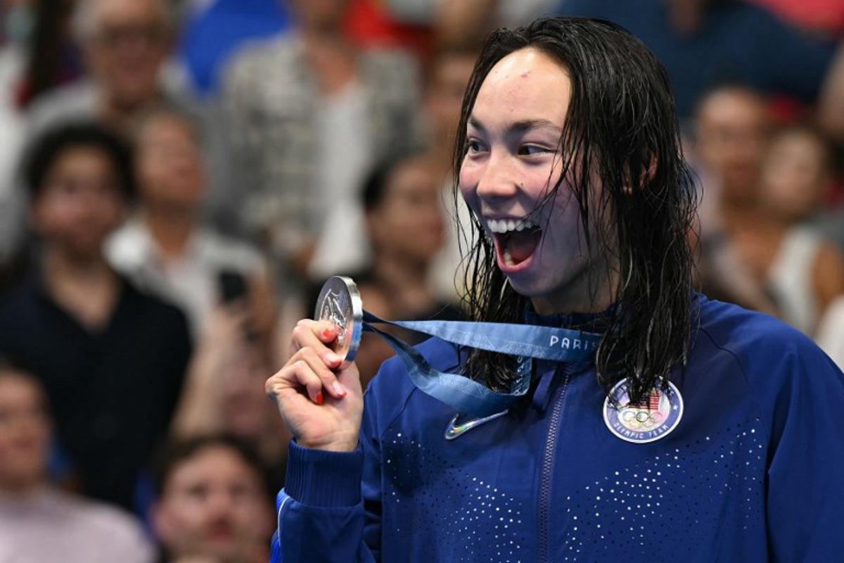 Silver medallist US' Torri Huske celebrates on the podium after the women's 100m freestyle swimming event during the Paris 2024 Olympic Games at the Paris La Defense Arena in Nanterre, west of Paris, on July 31, 2024.  Jonathan NACKSTRAND / AFP