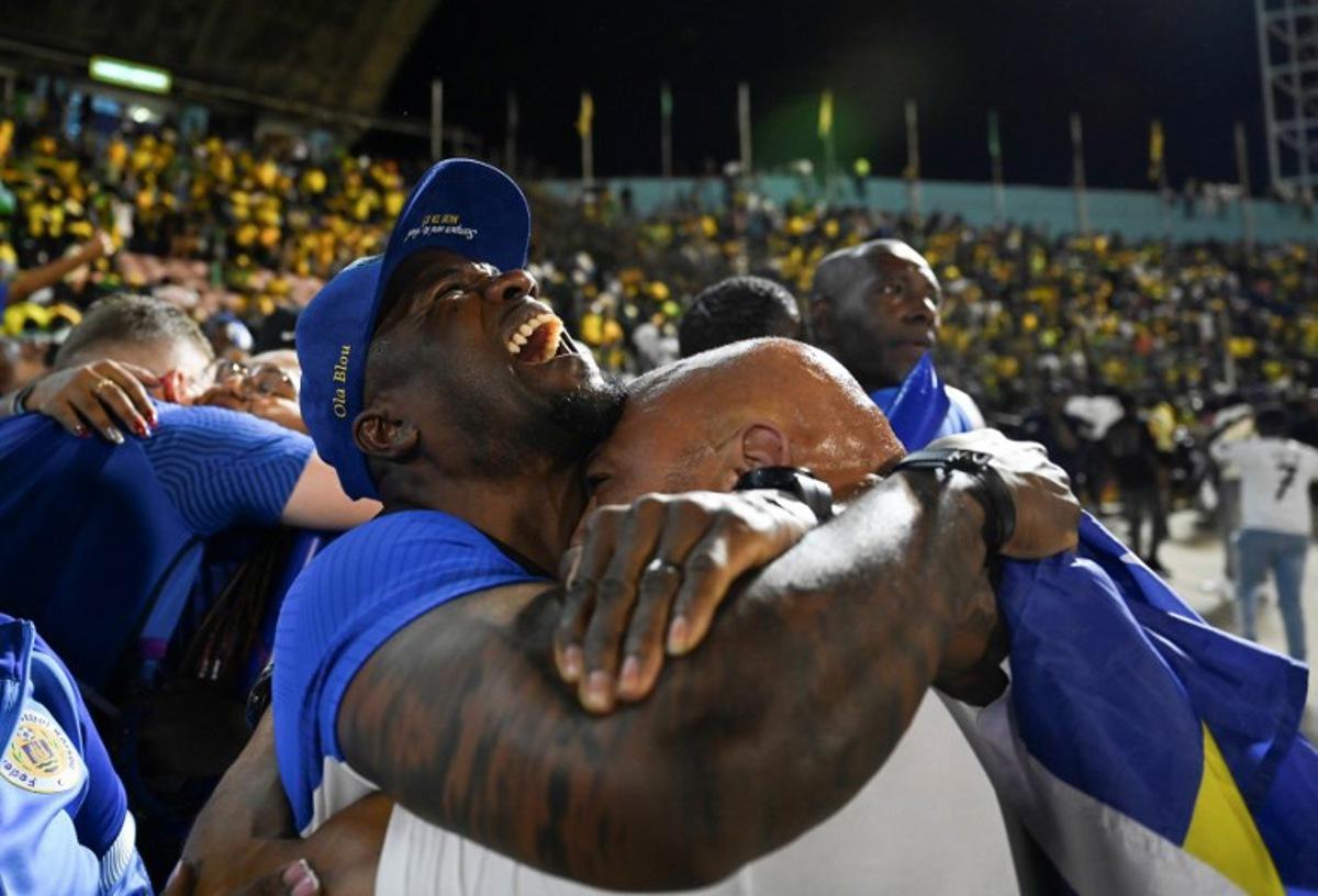 Curaçao fans celebrate World Cup 2026 qualification after a 0-0 draw with Jamaica at the National Stadium in Kingston, Jamaica on November 18, 2025. The tiny Caribbean nation of Curacao became the smallest country ever to qualify for the World Cup on November 18 as Haiti booked their return to the tournament for the first time in 52 years along with Panama. A nerve-shredding finale to the CONCACAF qualifying campaign saw Curacao -- with a population of just 156,000 -- squeeze into next year's finals in the United States, Canada and Mexico with a 0-0 draw against Jamaica in Kingston.  Ricardo MAKYN / AFP