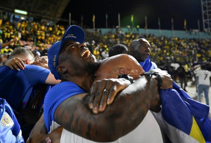 Curaçao fans celebrate World Cup 2026 qualification after a 0-0 draw with Jamaica at the National Stadium in Kingston, Jamaica on November 18, 2025. The tiny Caribbean nation of Curacao became the smallest country ever to qualify for the World Cup on November 18 as Haiti booked their return to the tournament for the first time in 52 years along with Panama. A nerve-shredding finale to the CONCACAF qualifying campaign saw Curacao -- with a population of just 156,000 -- squeeze into next year's finals in the United States, Canada and Mexico with a 0-0 draw against Jamaica in Kingston.  Ricardo MAKYN / AFP