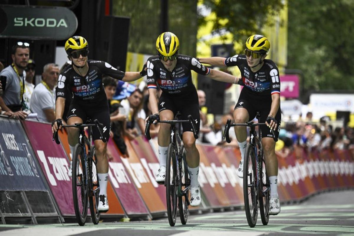 FDJ-SUEZ team's Dutch rider Demi Vollering (C) crosses the finish line as she is accompanied by her teammates FDJ-SUEZ team's Dutch rider Amber Kraak (L) and FDJ-SUEZ team's French rider Juliette Labous (R) after a fall during the 3rd stage (out of 9) of the fourth edition of the Women's Tour de France cycling race, 163.5 km from La Gacilly to Angers, in Angers, western France on July 28, 2025. The end of the stage 3 was marked by the heavy fall 3,700 meters from the finish line of the favorite of the event, the Dutchwoman Demi Vollering, who took time to get back up but was classified in the same time as the first competitors, the fall having occurred in the "sprint zone" of the last five kilometers. JULIEN DE ROSA / AFP
