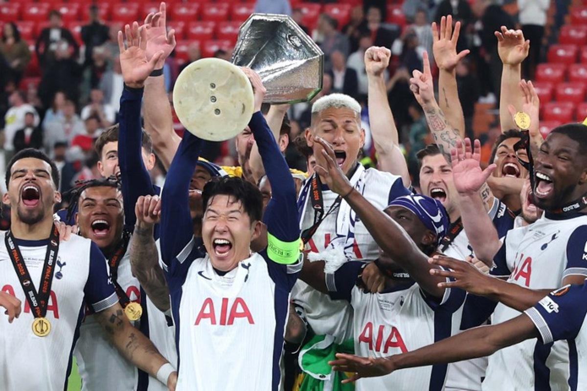 Tottenham Hotspur's players including South Korean forward #07 Son Heung-Min celebrate with the trophy after the UEFA Europa League final football match between Tottenham Hotspur and Manchester United at the San Mames stadium in Bilbao on May 21, 2025.  Pierre-Philippe MARCOU / AFP