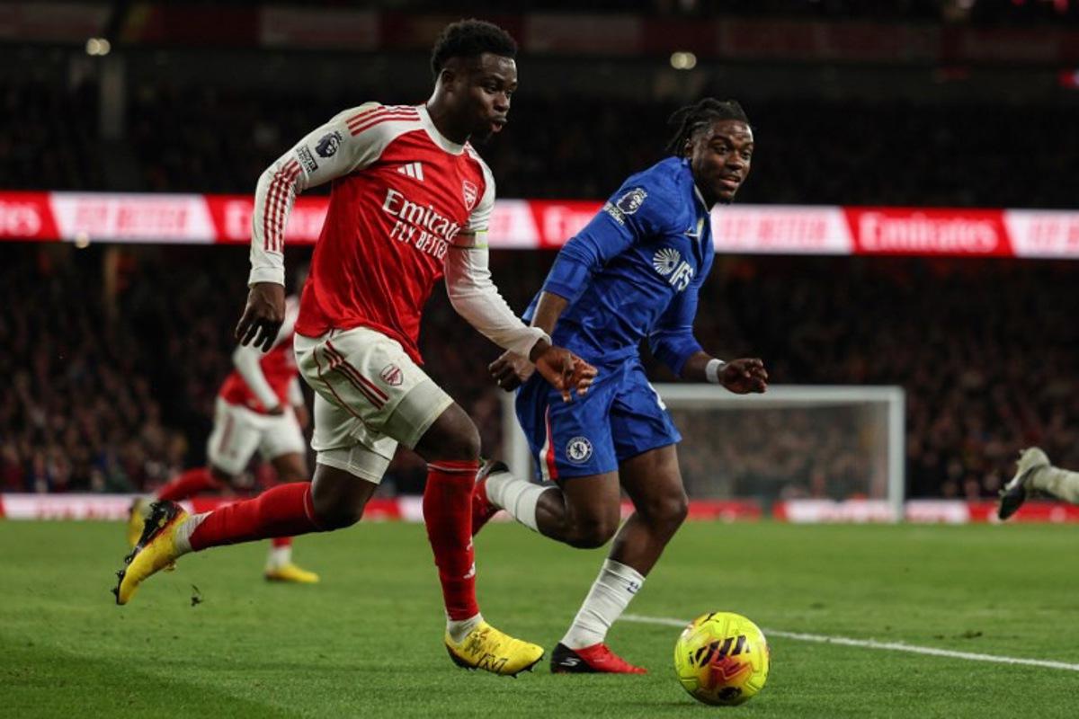 Chelsea's Belgian midfielder #45 Romeo Lavia (R) chases after Arsenal's English midfielder #07 Bukayo Saka (L) during the English Premier League football match between Arsenal and Chelsea at the Emirates Stadium in London on March 1, 2026.   Adrian Dennis / AFP