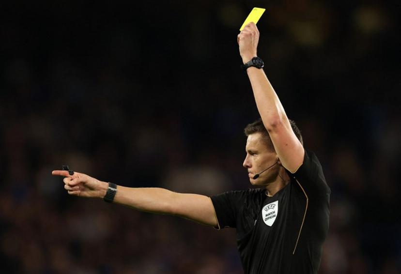 German referee Daniel Siebert shows a yellow card to Benfica's Argentinian defender #30 Nicolas Otamendi (unseen) during the UEFA Champions League, league phase football match between Chelsea and Benfica at Stamford Bridge in London on September 30, 2025.  Adrian Dennis / AFP