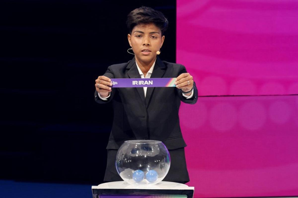 Indian footballer Sangita Basfore holds up Iran during the 2026 AFC Women's Asian Cup football draw in Sydney on July 29, 2025. The 2026 AFC Women's Asian Cup will be hosted by Australia, and will run from March 1-21, 2026.  DAVID GRAY / AFP