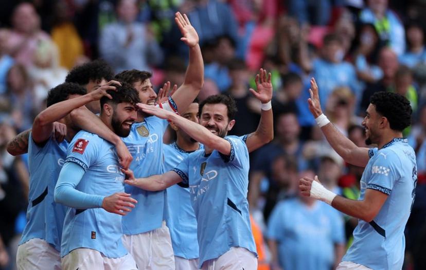 Manchester City's Croatian defender #24 Josko Gvardiol (3L) is mobbed by teammates after scoring the team's second goal during the English FA Cup semi-final football match between Nottingham Forest and Manchester City at Wembley Stadium in north London on April 27, 2025.  Adrian Dennis / AFP