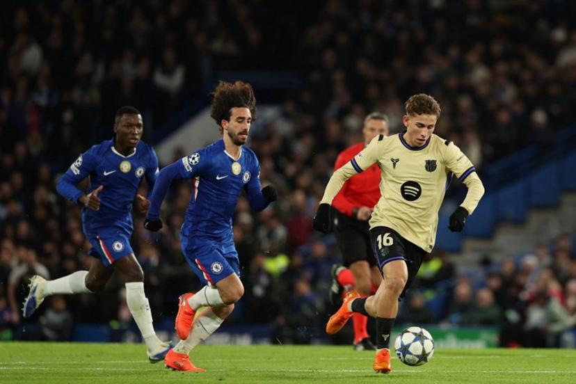 Barcelona's Spanish midfielder #16 Fermin Lopez runs with the ball during the UEFA Champions League league-phase football match between Chelsea and Barcelona at Stamford Bridge in London on November 25, 2025.  Adrian Dennis / AFP