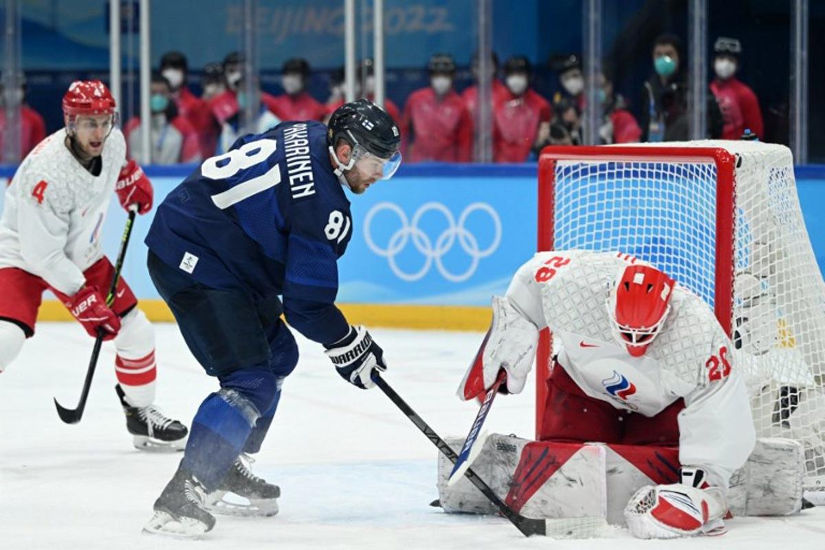 Finland's Iiro Pakarinen (C) shoots the puck as Russian Olympic Committee's goaltender Ivan Fedotov (R) defends the goal during the men's gold medal match of the Beijing 2022 Winter Olympic Games ice hockey competition between Finland and Russia's Olympic Committee, at the National Indoor Stadium in Beijing on February 20, 2022.  Kirill KUDRYAVTSEV / AFP