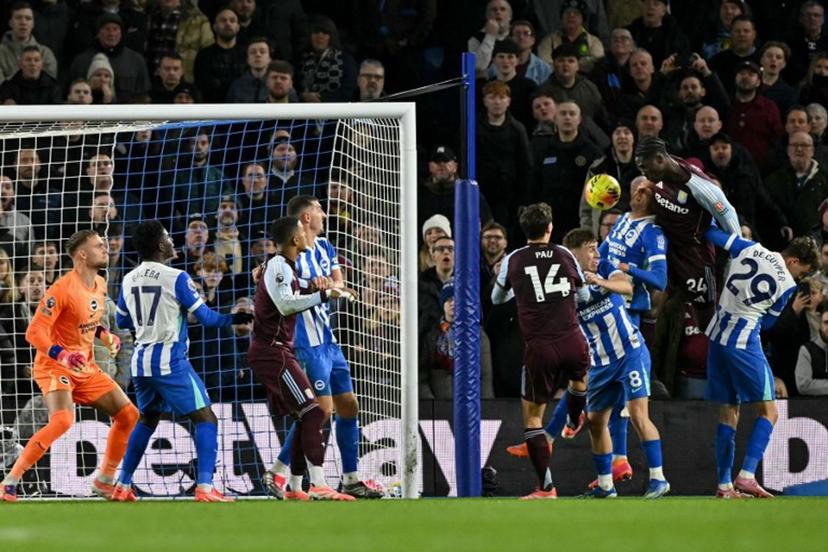 Aston Villa's Belgian midfielder #24 Amadou Onana (2nd R) goes for a header and scores his team's third goal during the English Premier League football match between Brighton and Hove Albion and Aston Villa at the American Express Community Stadium in Brighton, southern England on December 3, 2025.  Glyn KIRK / AFP
