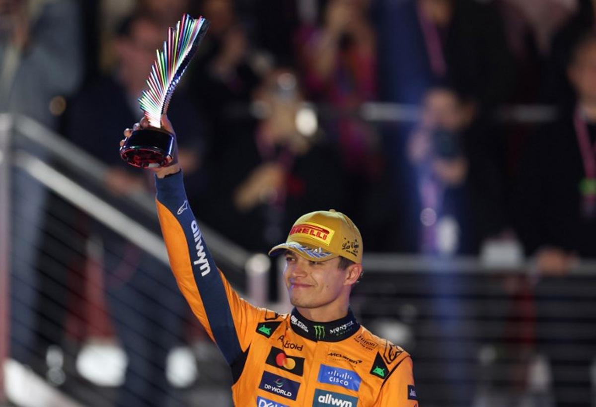 Second place finisher McLaren's British driver Lando Norris holds his trophy on the podium after the Las Vegas Formula One Grand Prix at the Las Vegas Strip Circuit in Las Vegas, Nevada, on November 22, 2025. Formula One world champion Max Verstappen produced a masterful drive to win the Las Vegas Grand Prix on Saturday as McLaren's Lando Norris finished second to edge closer to a maiden drivers' title. Red Bull ace Verstappen pounced on a slip by pole-sitter Norris on the first turn of Sin City's street circuit to grab the lead and controlled the race thereafter to claim the 69th Grand Prix win of his career, finishing more than 20 seconds clear.  Patrick T. Fallon / AFP