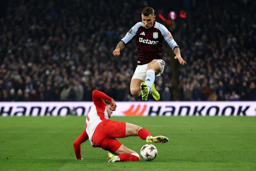Aston Villa's French defender  #12 Lucas Digne jumps over a tackle from Salzburg's Austrian midfielder #37 Tim Trummer during the UEFA Europa League league-stage football match between Aston Villa and RB Salzburg at Villa Park in Birmingham, central England on January 29, 2026.  Darren Staples / AFP