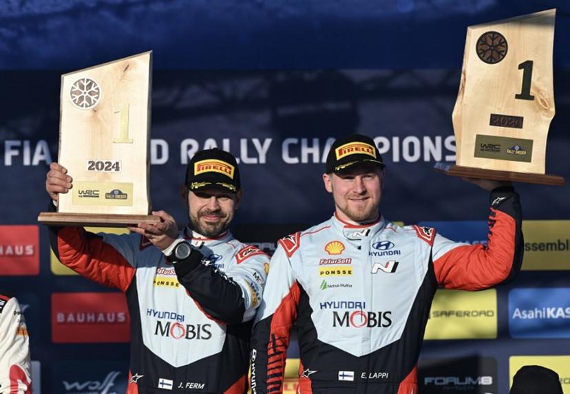 Winner Esapekka Lappi of Finland and his co-driver Janne Ferm of Finland pose with their trophies on the podium of the FIA World Rally Championship near Umea, Sweden, on February 18, 2024.  Jonathan NACKSTRAND / AFP