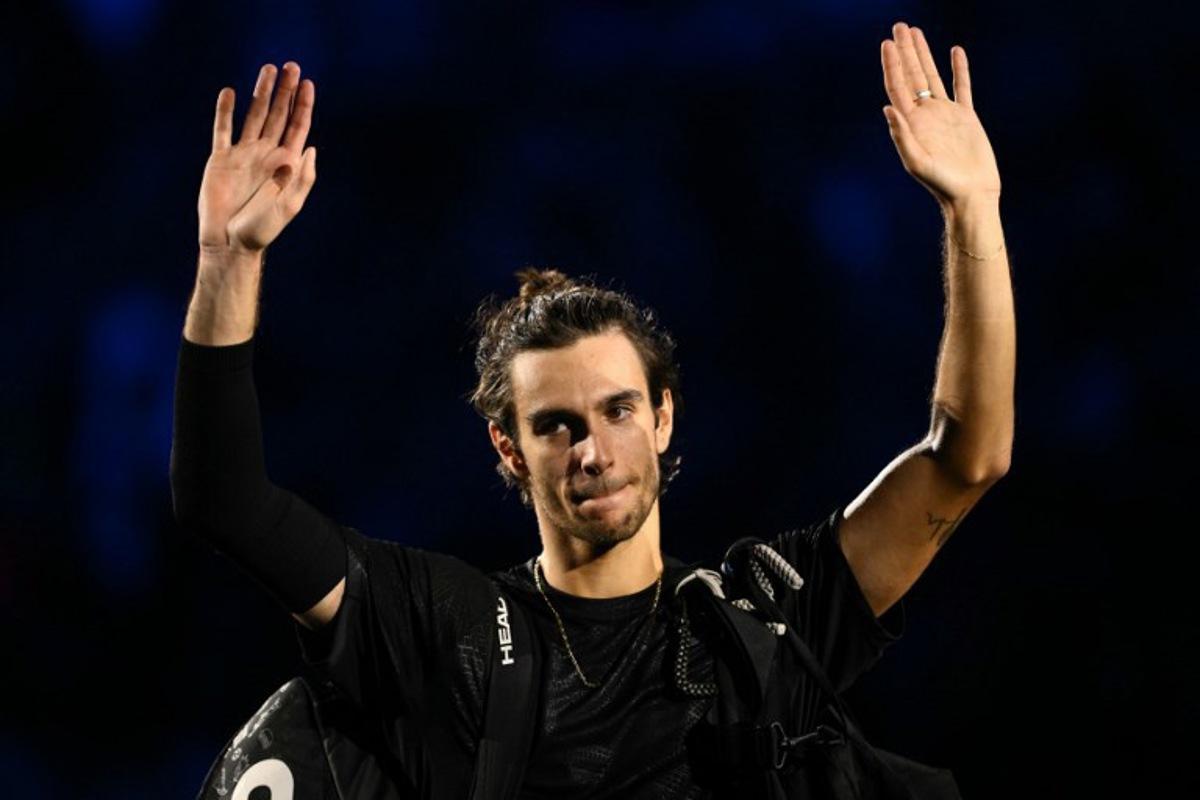 Italy's Lorenzo Musetti waves as he leaves the court after being defeated by Spain's Carlos Alcaraz at the ATP Finals tennis tournament in Turin on November 13, 2025.  Marco BERTORELLO / AFP