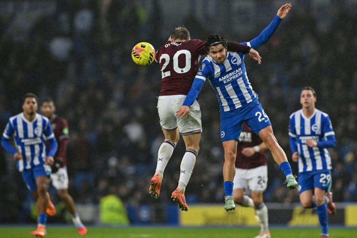 Brighton's Turkish defender #24 Ferdi Kadioglu (front R) clashes with West Ham United's English striker #20 Jarrod Bowen (centre L) during the English Premier League football match between Brighton and Hove Albion and West Ham United at the American Express Community Stadium in Brighton, southern England on December 7, 2025.  Glyn KIRK / AFP