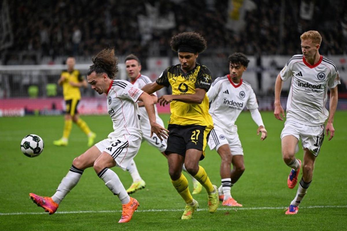 Frankfurt's Belgian defender #03 Arthur Theate (L) and Dortmund's German forward #27 Karim Adeyemi vie for the ball during the German Cup (DFB Pokal) second round football match between Eintracht Frankfurt and BVB Borussia Dormund in Frankfurt, western Germany on October 28, 2025.  Kirill KUDRYAVTSEV / AFP