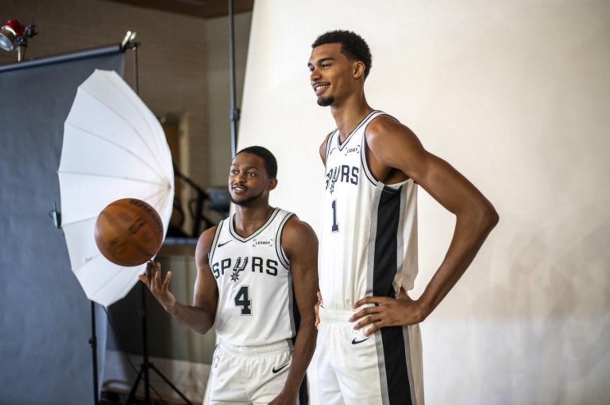 French basketball player Victor Wembanyama (R) and US player De'Aaron Fox (L) pose for promotional photos during the San Antonio Spurs media day at the Victory Capital Performance Center in San Antonio, Texas on September 29, 2025. Wembanyama has been cleared by the team's medical staff to play for the upcoming season. SERGIO FLORES / AFP
