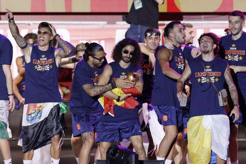 Spain's defender Marc Cucurella (C) cradles the trophy in his arms as Spain's players celebrate on a stage at Cibeles Square in Madrid on July 20, 2026, one day after winning their second World Cup title following a 1-0 victory against Argentina. Spain's World Cup winners come back home to a heroes' welcome in Madrid, where a million fans are expected to greet them after a night of raucous celebrations across the country. Oscar DEL POZO / AFP