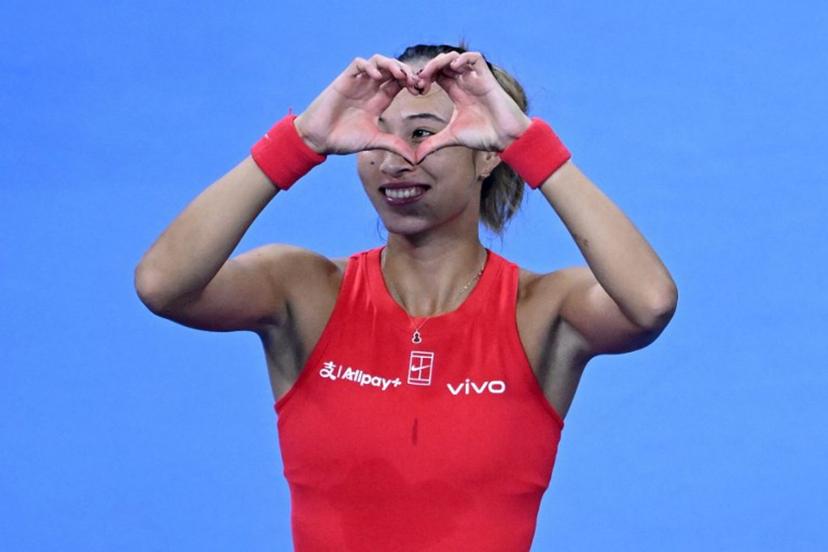China's Zheng Qinwen make a heart sign to spectators for her birthday wishes as she celebrates beating Armenia's Alina Charaeva in their women's singles match at the China Open tennis tournament in Beijing on October 7, 2026.  ADEK BERRY / AFP