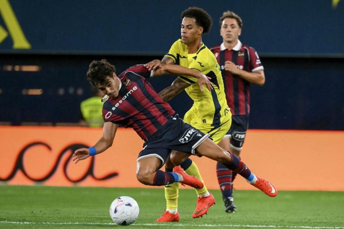 Levante's Spanish defender #23 Manuel Sanchez (L) is challenged by Villarreal's Canadian midfielder #17 Tajon Buchanan during the Spanish league football match between Villarreal CF and Levante UD at La Ceramica Stadium in Vila-real on September 20, 2026.  JOSE JORDAN / AFP
