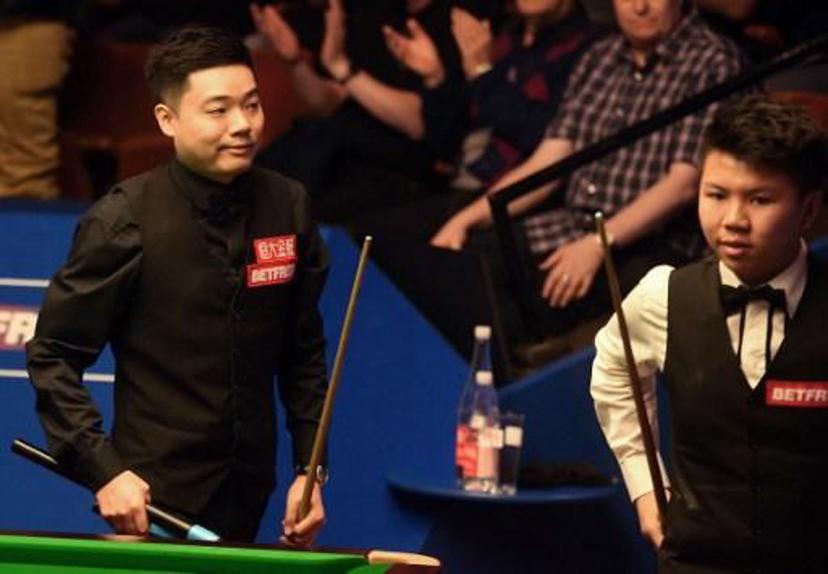 China's Ding Junhui (L) reacts after winning against China's Zhou Yuelong during their first round game of the World Snooker Championships in Sheffield, northern England, on April 18, 2017.  Ding Junhui won the match 10-5. PAUL ELLIS / AFP