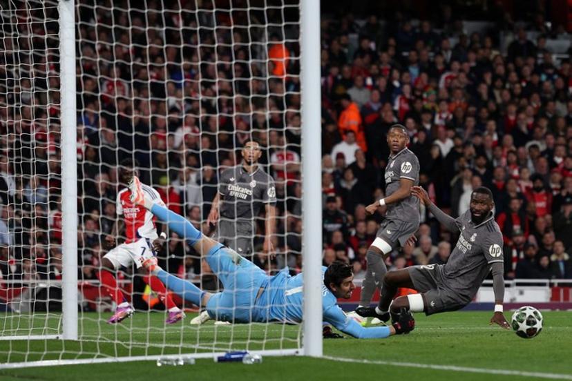 Real Madrid's Belgian goalkeeper #01 Thibaut Courtois saves a shot from Arsenal's English midfielder #07 Bukayo Saka during the UEFA Champions League Quarter final first leg football match between Arsenal and Real Madrid, at the Emirates Stadium, in London, on April 8, 2025.   Adrian Dennis / AFP