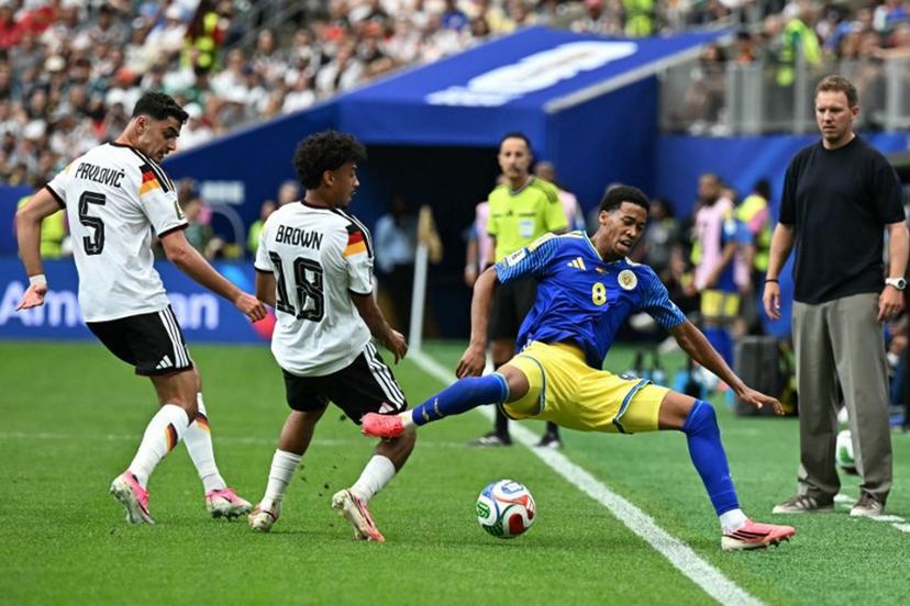 Curacao's midfielder #08 Livano Comenencia (C) is tackled by Germany's defender #18 Nathaniel Brown (2ndL) as Germany's head coach Julian Nagelsmann (R) looks on during the 2026 World Cup Group E football match between Germany and Curacao at the Houston Stadium in Houston on June 14, 2026.   Paul ELLIS / AFP