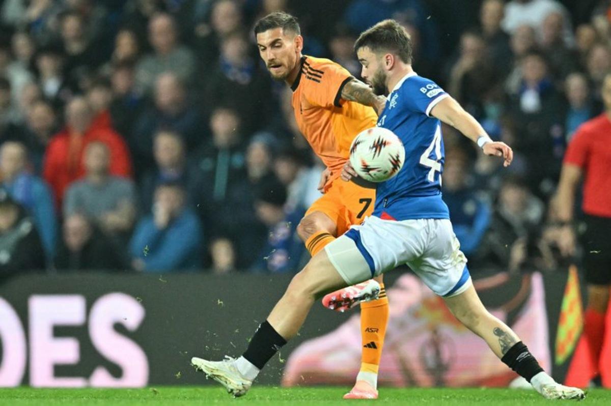 Roma's Italian midfielder #07 Lorenzo Pellegrini (L) plays the ball past Rangers' Belgian midfielder #43 Nicolas Raskin (R) during the UEFA Europa League league-stage football match between Rangers and Roma at Ibrox Stadium in Glasgow on November 6, 2025.  ANDY BUCHANAN / AFP
