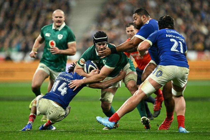 Ireland's number number eight Caelan Doris is tackled by France's wing Théo Attissogbe (#14) and France's lock Emmanuel Meafou (2nd R) during the Six Nations international rugby union match between France and Ireland at the Stade de France in Saint-Denis, Paris' suburb, on February 5, 2026.  Julie SEBADELHA / AFP