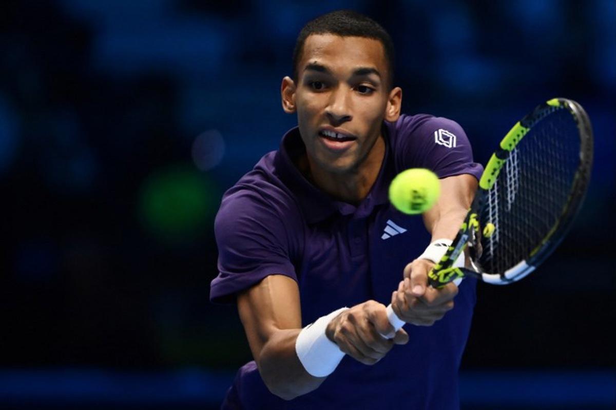 Canada's Felix Auger Aliassime plays a backhand return against Germany's Alexander Zverev during their men's single tennis match at the ATP Finals tennis tournament, in Turin, on November 14, 2025.  MARCO BERTORELLO / AFP