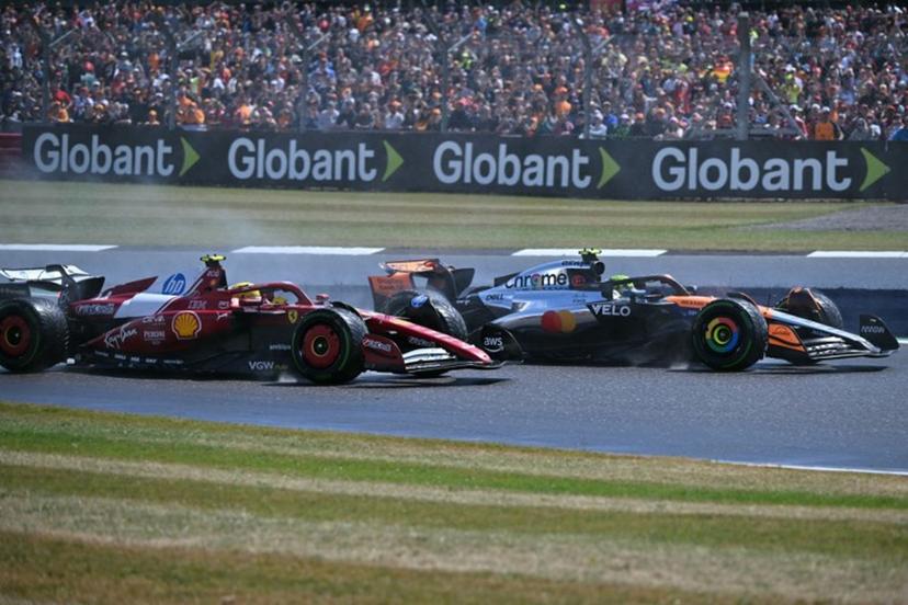 Ferrari's British driver Lewis Hamilton (L) challenges McLaren's British driver Lando Norris (R) on the first lap of the Formula One British Grand Prix at the Silverstone motor racing circuit in Silverstone, central England, on July 6, 2025.  Andrej ISAKOVIC / AFP
