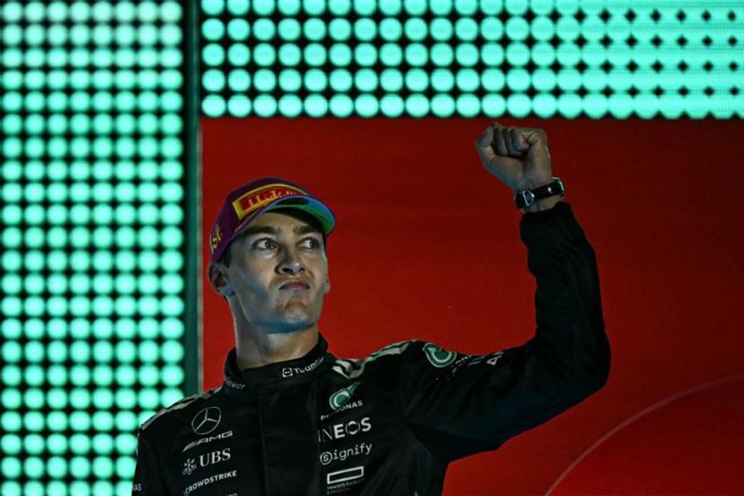First-placed Mercedes' British driver George Russell celebrates on the podium after the Formula One Singapore Grand Prix night race at the Marina Bay Street Circuit in Singapore on October 5, 2025.  Lillian SUWANRUMPHA / AFP