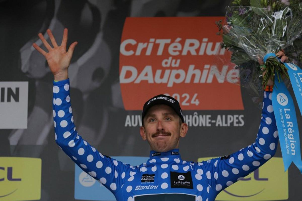 Team Q36.5's British rider Mark Donovan wearing the best climber's dotted jersey celebrates on the podium after the first stage of the 76th edition of the Criterium du Dauphine cycling race, 172,5km between in Saint-Pourcain-sur-Sioule, central France, on June 2, 2024.  Thomas SAMSON / AFP