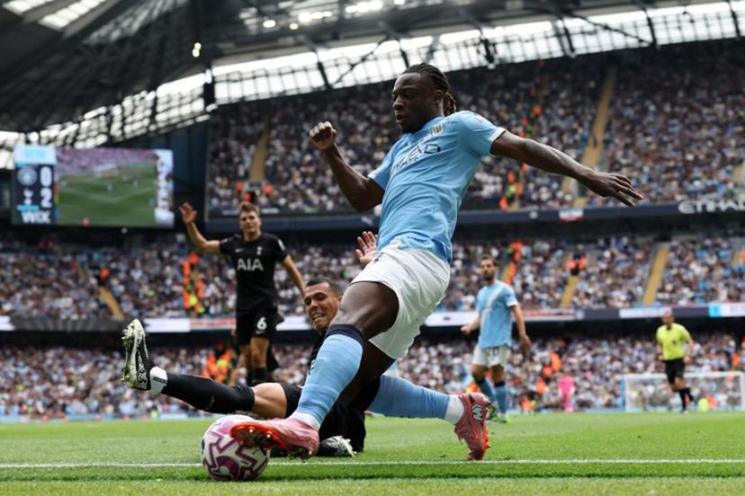 Tottenham Hotspur's Spanish defender #23 Pedro Porro slides in to tackle Manchester City's Belgian midfielder #11 Jeremy Doku during the English Premier League football match between Manchester City and Tottenham Hotspur at the Etihad Stadium in Manchester, north west England, on August 23, 2025.  Darren Staples / AFP
