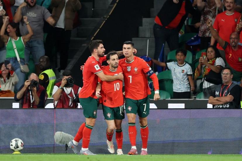 Portugal's forward #16 Cristiano Ronaldo celebrates with his teammates after scoring the equalising goal during the 2026 World Cup qualifiers Europe zone group F football match between Portugal and Hungary at Jose Alvalade stadium in Lisbon on October 14, 2025.  PATRICIA DE MELO MOREIRA / AFP