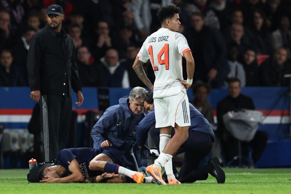 Paris Saint-Germain's Moroccan defender #02 Achraf Hakimi (L) reacts after picking up an injury, next Bayern Munich's Colombian forward #14 Luis Diaz (R), during the UEFA Champions League, league phase day 4, football match between Paris Saint-Germain (PSG) and FC Bayern Munich at the Parc des Princes in Paris, on November 4, 2025.  Thomas SAMSON / AFP