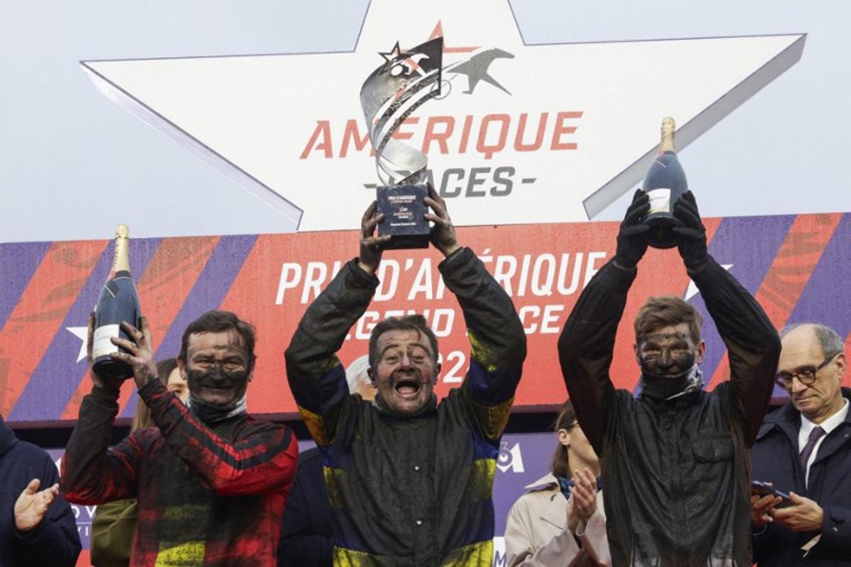 (From L) Second-placed French jockey Sebastien Ernault driver of Josh Power, winner French jockey Franck Nivard, driver of Hokkaido Jiel and third-placed French jockey Paul Philippe Ploquin driver of Epic Kronos celebrate on the podium after the 105th Grand Prix d'Amerique harness racing horse race at the Vincennes Hippodrome in Paris on January 25, 2026.   GEOFFROY VAN DER HASSELT / AFP