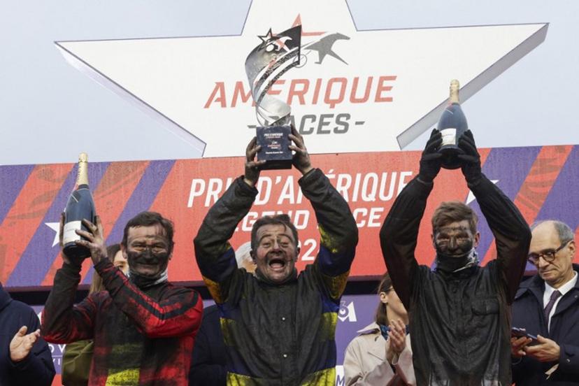 (From L) Second-placed French jockey Sebastien Ernault driver of Josh Power, winner French jockey Franck Nivard, driver of Hokkaido Jiel and third-placed French jockey Paul Philippe Ploquin driver of Epic Kronos celebrate on the podium after the 105th Grand Prix d'Amerique harness racing horse race at the Vincennes Hippodrome in Paris on January 25, 2026.   GEOFFROY VAN DER HASSELT / AFP