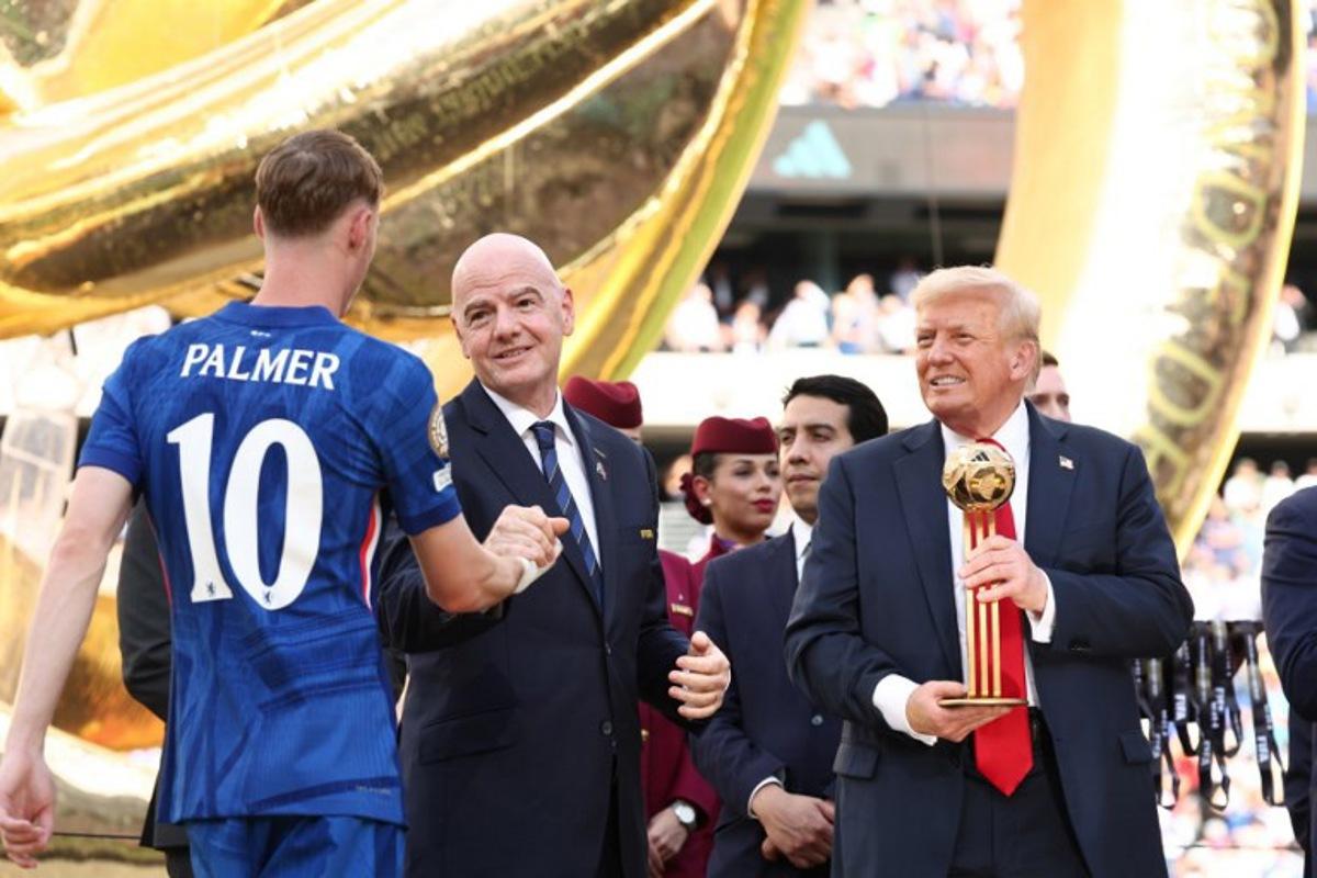 FIFA president Gianni Infantino and US President Donald Trump present Chelsea's English midfielder #10 Cole Palmer with the golden ball trophy after Chelsea won against Paris St Germain in the FIFA Club World Cup final, at the MetLife Stadium in East Rutherford, New Jersey on July 13, 2025.   KEVIN LAMARQUE / POOL / AFP
