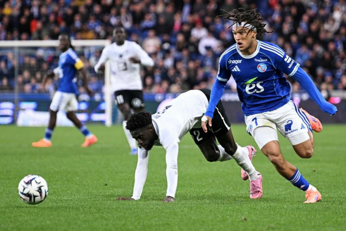 Strasbourg's Belgian midfielder #07 Diego Moreira (R) fights for the ball with Angers' Haitian defender #02 Carlens Arcus during the French L1 football match between RC Strasbourg Alsace and SCO Angers at the Stade de la Meinau in Strasbourg, eastern France on October 5, 2025.   SEBASTIEN BOZON / AFP