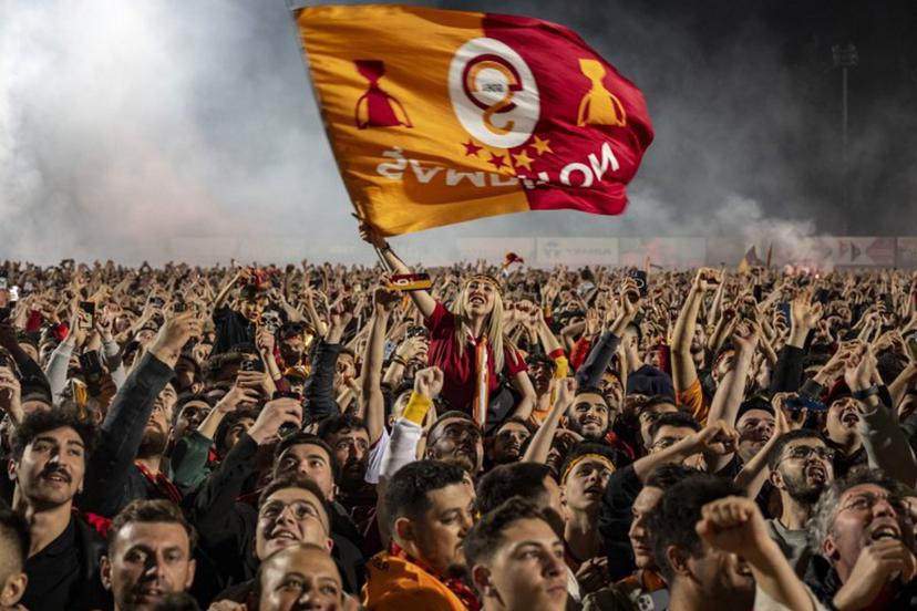 Galatasaray supporters celebrate their team's victory at the end of the Turkish Super Lig football match between Galatasaray and Konyaspor at the Florya Metin Oktay facilities in Istanbul, on May 27, 2024.   Yasin AKGUL / AFP