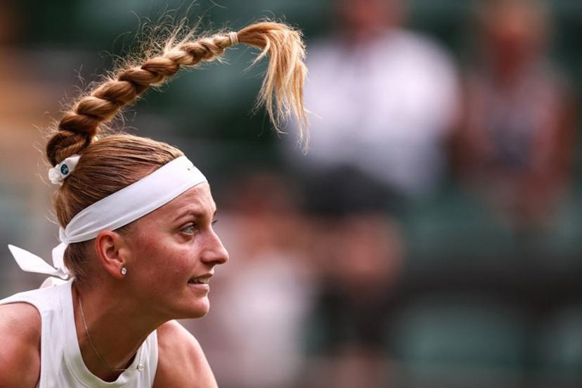 The hair of Czech Republic's Petra Kvitova move over head as she serves the ball to US player Emma Navarro during their women's singles first round tennis match on the second day of the 2025 Wimbledon Championships at The All England Lawn Tennis and Croquet Club in Wimbledon, southwest London, on July 1, 2025.  HENRY NICHOLLS / AFP