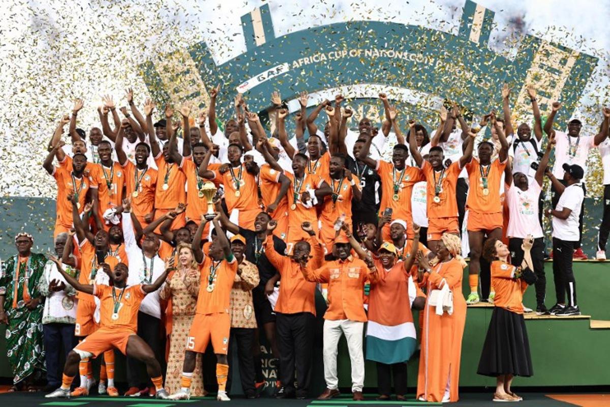 Ivory Coast's forward #15 Max-Alain Gradel (C) lifts the Africa Cup of Nations trophy on the podium after Ivory Coast won the Africa Cup of Nations (CAN) 2024 final football match between Ivory Coast and Nigeria at Alassane Ouattara Olympic Stadium in Ebimpe, Abidjan on February 11, 2024.  FRANCK FIFE / AFP