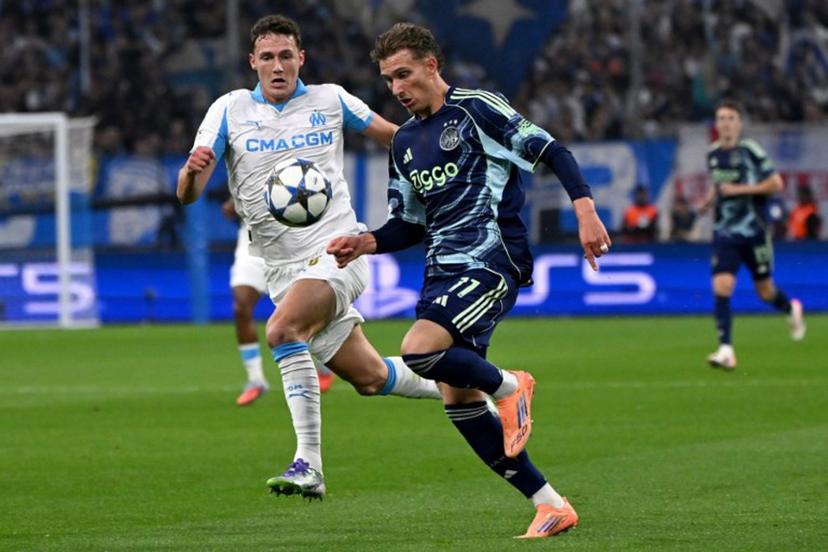 Marseille's French defender #28 Benjamin Pavard (L) and Ajax's Belgian forward #11 Mika Godts fight for the ball during the UEFA Champions League, league phase day 2, football match between Olympique de Marseille (FRA) and AFC Ajax (NED) at the Velodrome stadium, in Marseille on September 30, 2025.  Miguel MEDINA / AFP