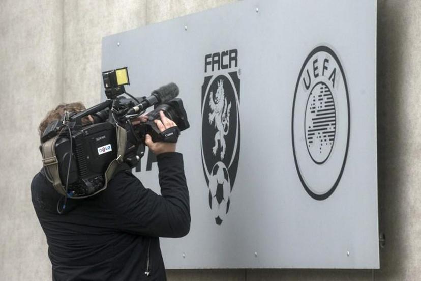A cameraman of Czech commercial television TV Nova shoots the logo of Czech Football Association (FACR) in front of the FACR headquarters on October 16, 2020 in Prague. Czech police detained 19 people including deputy Czech FA head Roman Berbr over corruption and match-fixing following a nationwide raid, a prosecutor and local media said. Michal Cizek / AFP