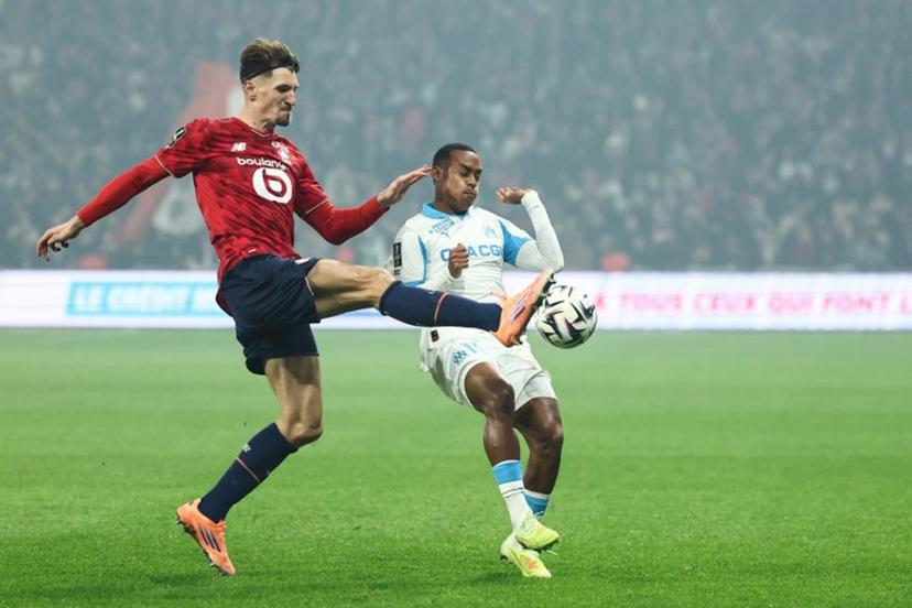 Lille's Belgian defender #12 Thomas Meunier (L) and Marseille's Brazilian forward #14 Igor Paixao fight for the ball during the French L1 football match between Lille LOSC and Olympique de Marseille (OM) at the Pierre-Mauroy stadium in Villeneuve-d'Ascq, northern France, on December 5, 2025.  Sameer AL-DOUMY / AFP